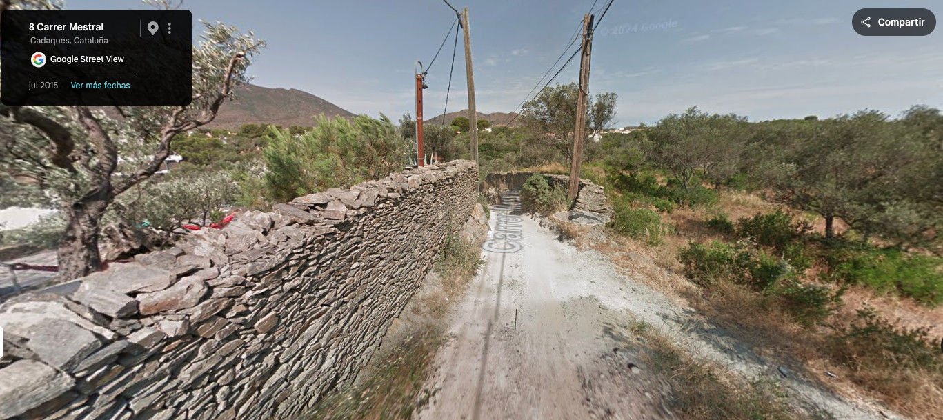 Camino de tierra estrecho entre muros de piedra en Cadaqués (Street View)